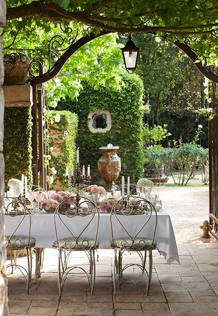 toskański ogród z metalowym stołem ogrodowym