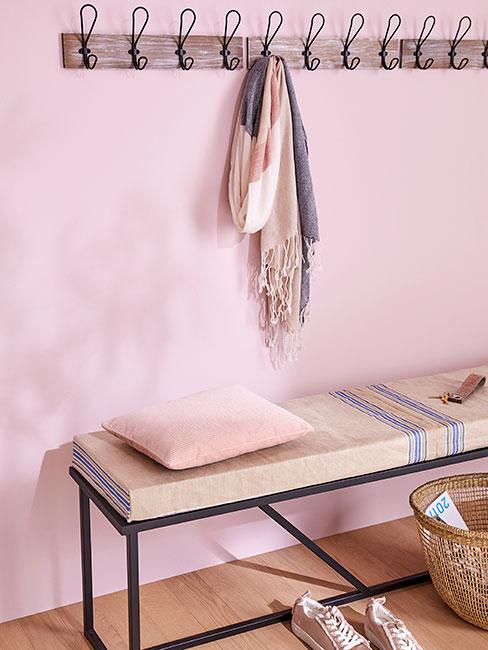 Przedpokój w stylu skandynawskim z jasnoróżową ścianą i minimalistycznym wieszakiem na ścianie