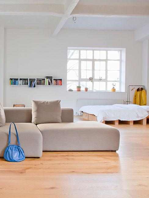 jasna salon z łóżkiem na paletach w lofcie