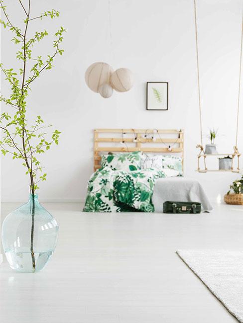 jasna sypialnia loft z łóżkiem z palet i dużym wazonem podłogowym