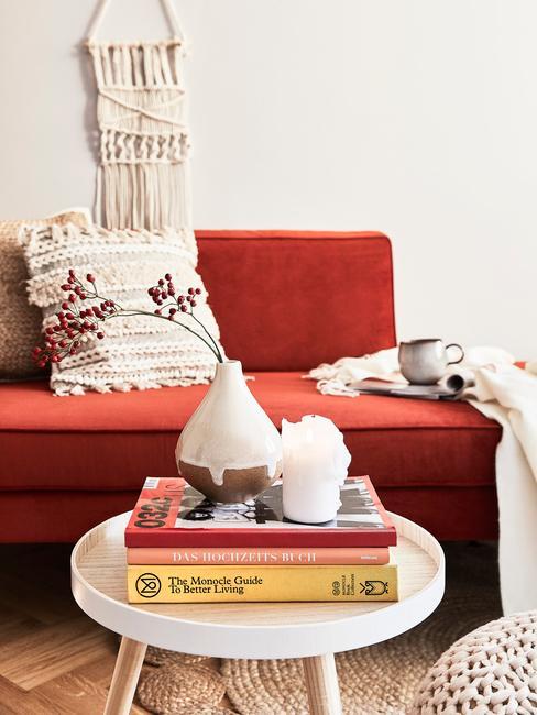 Salon z bordową kanapą, książki ułożone na stoliku