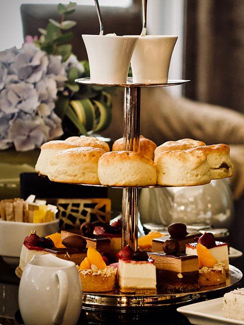 Angielski podwieczorek na etażerce z ciastkami scones i małymi deserami