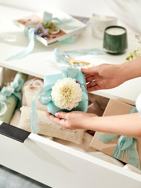 Mały turkusowy prezent z dekoracyjnym kwiatem