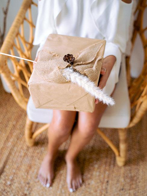 Prezent urodzinowy w szarym papierze ozdobiony trawą