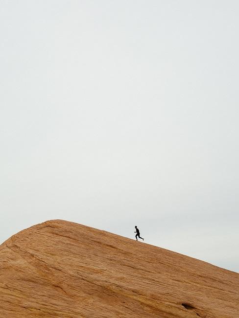 W dali biegnąca postać po piasku