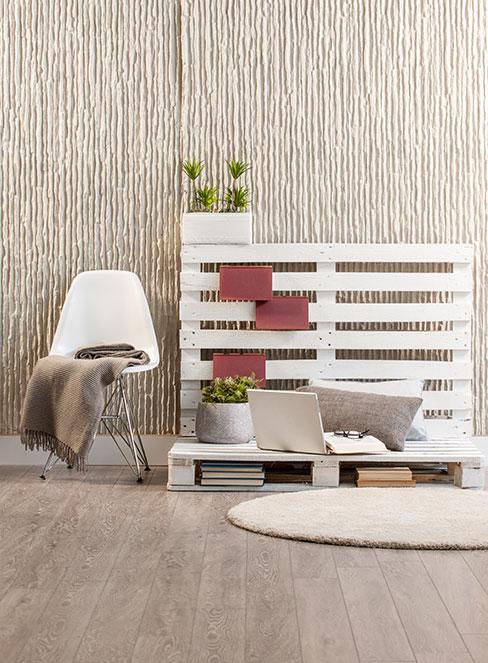 Ławka z palet obok krzesła i dywanu na ziemi