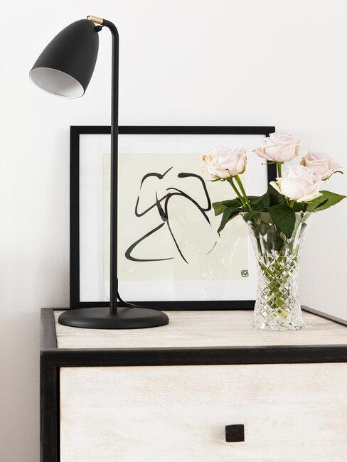 Rysunek oprawiony w ramkę stojący na szafce