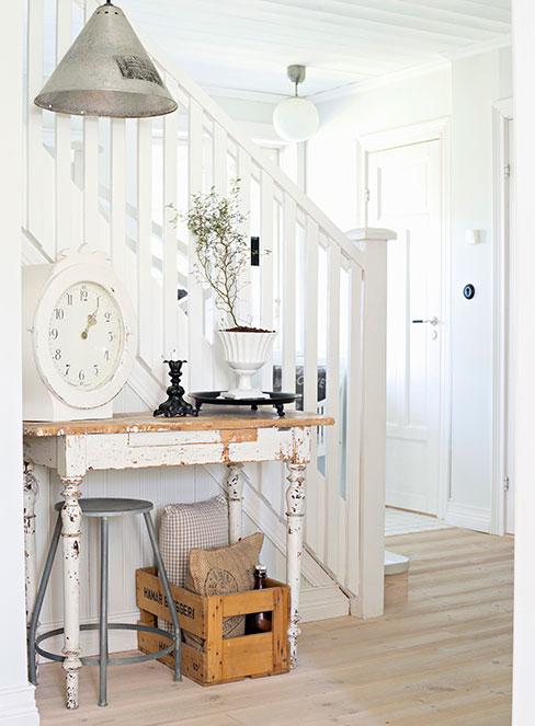 biała postarzona konsola w przedpokoju udekorowana dodatkami w stylu shabby chic
