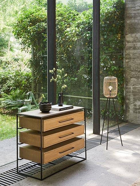 nowoczesna komoda z drewnaianymi szufladami w metalowej ramie przy dużym oknie w lofcie