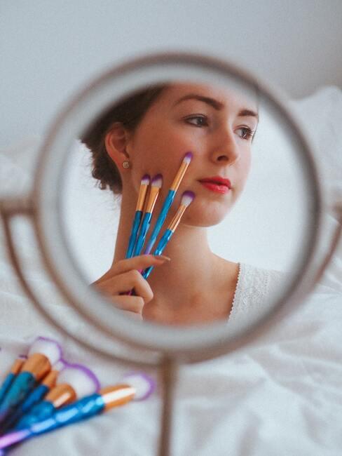 kobieta z pędzlami do makijażu
