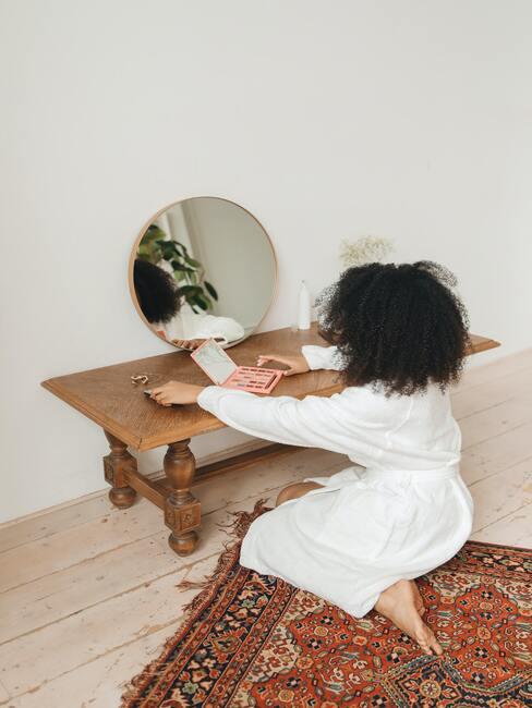 kobieta w białym szlafroku robiąca makijaż ślubny