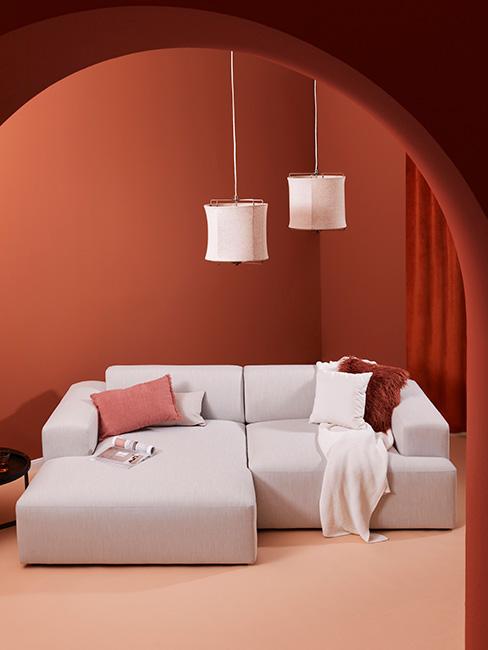 salon z jasną sofą modułową i ścianami w kolorze terakoty