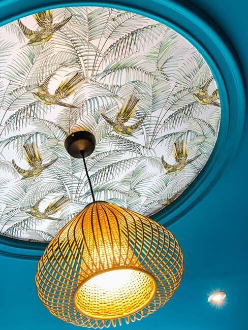 Sufit w kolorze morskim z biało-złotym zdobieniem i złotą wiszącą lampą
