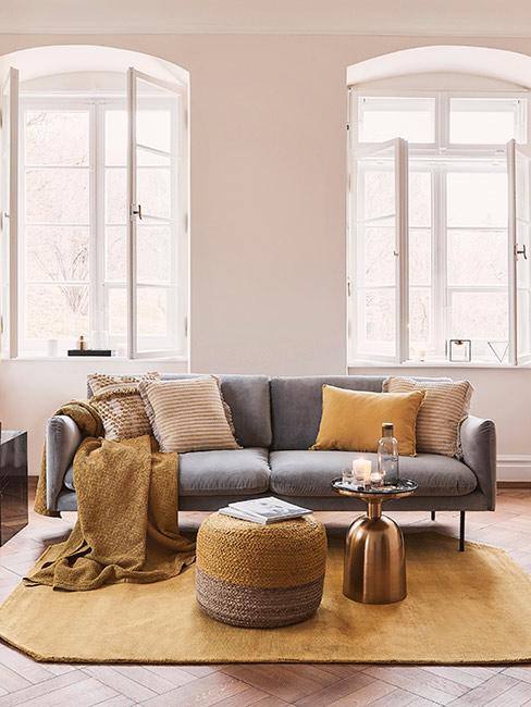 szara sofa z aksamitu z musztardowymi poduszkami i dekoracjami