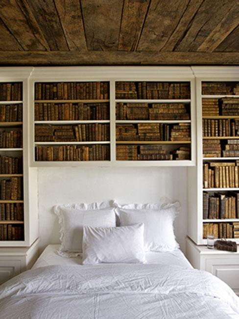 Wnętrze w stylu Steampunk, ściana za łóżkiem wypełniona książkami, sufit ze starego drewna i łó