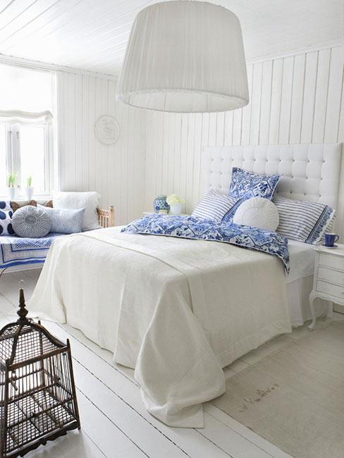 sypialnia w bieli z niebieskimi poduszkami