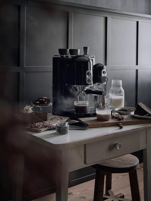 Czarna kuchnia: czarny ekspres do kawy na jasnej konsoli w kuchni na tle czarnej ściany