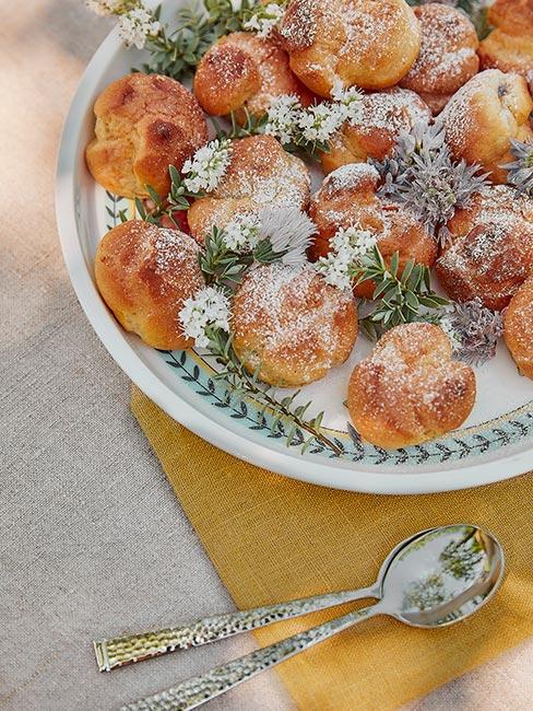 małe pączki z cukrem pudrem w białozielonej misce