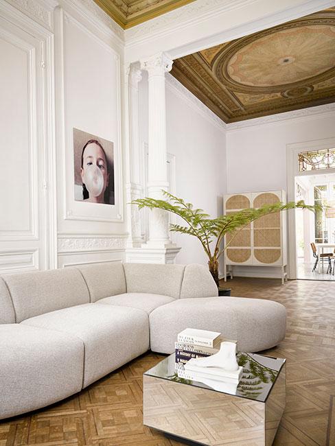 nowoczesny salon z szarą sofą modułową w kamienicy z lamperią na ścianie