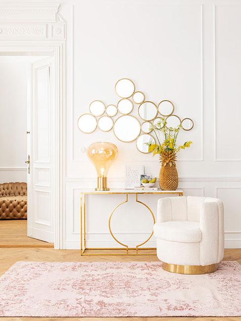modern classic: przedpokój w jasnych barwach, białe ściany, drewniana podłoga, konsola, lustro i podstawa małego fotela w kolorze złotym