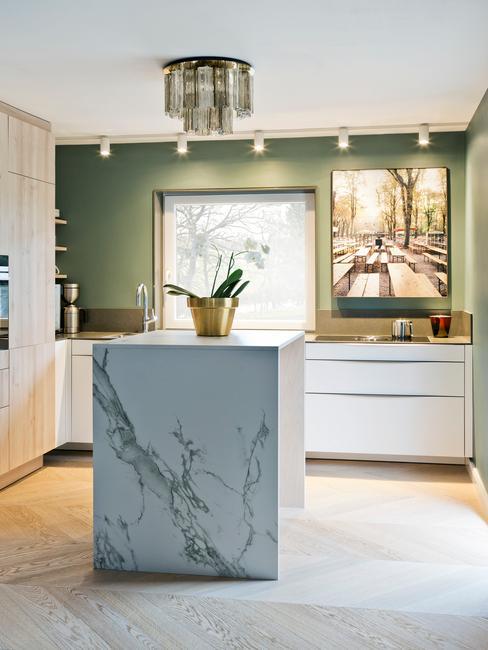 marmurowa wyspa w kuchni glamour z zieloną ścianą