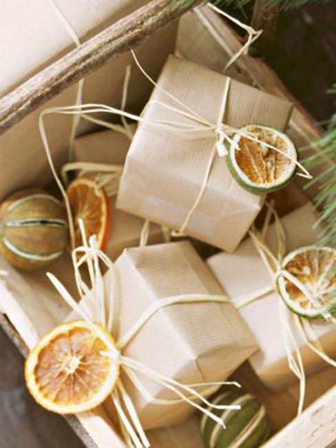 prezenty świąteczne opakowane szarym papierem i słomkowym sznurkiem z suszoną pomarańczą
