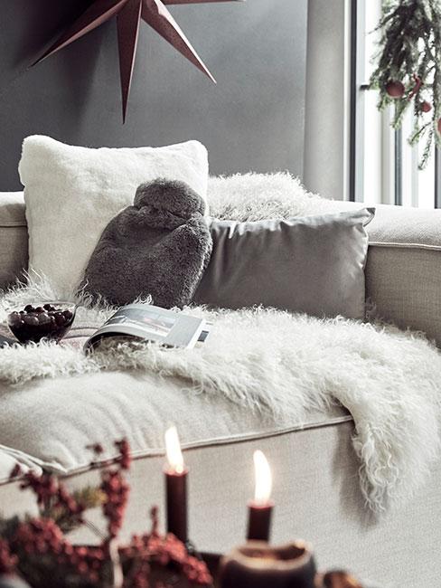 Przytulny kącik w salonie z futrzanymi termoforami z dekoracją świąteczną na oknie