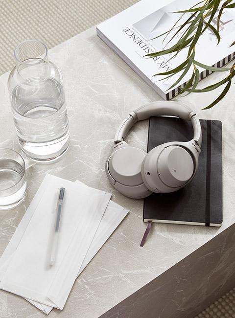 popielate słuchawki na notesie na stoliku