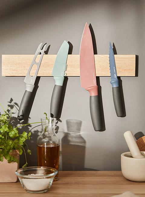 Kolorowe noże na magnetycznej listwie w kuchni