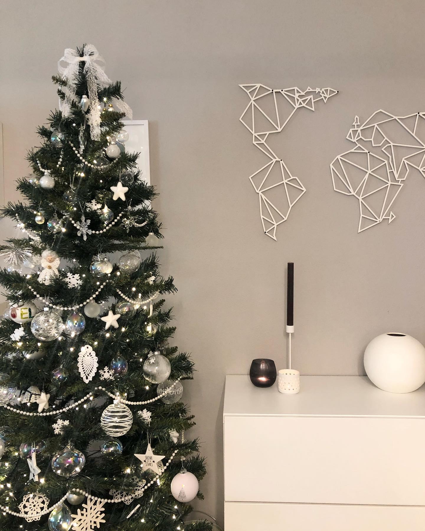 Zielona choinka z białymi dekoracjami w salonie boho