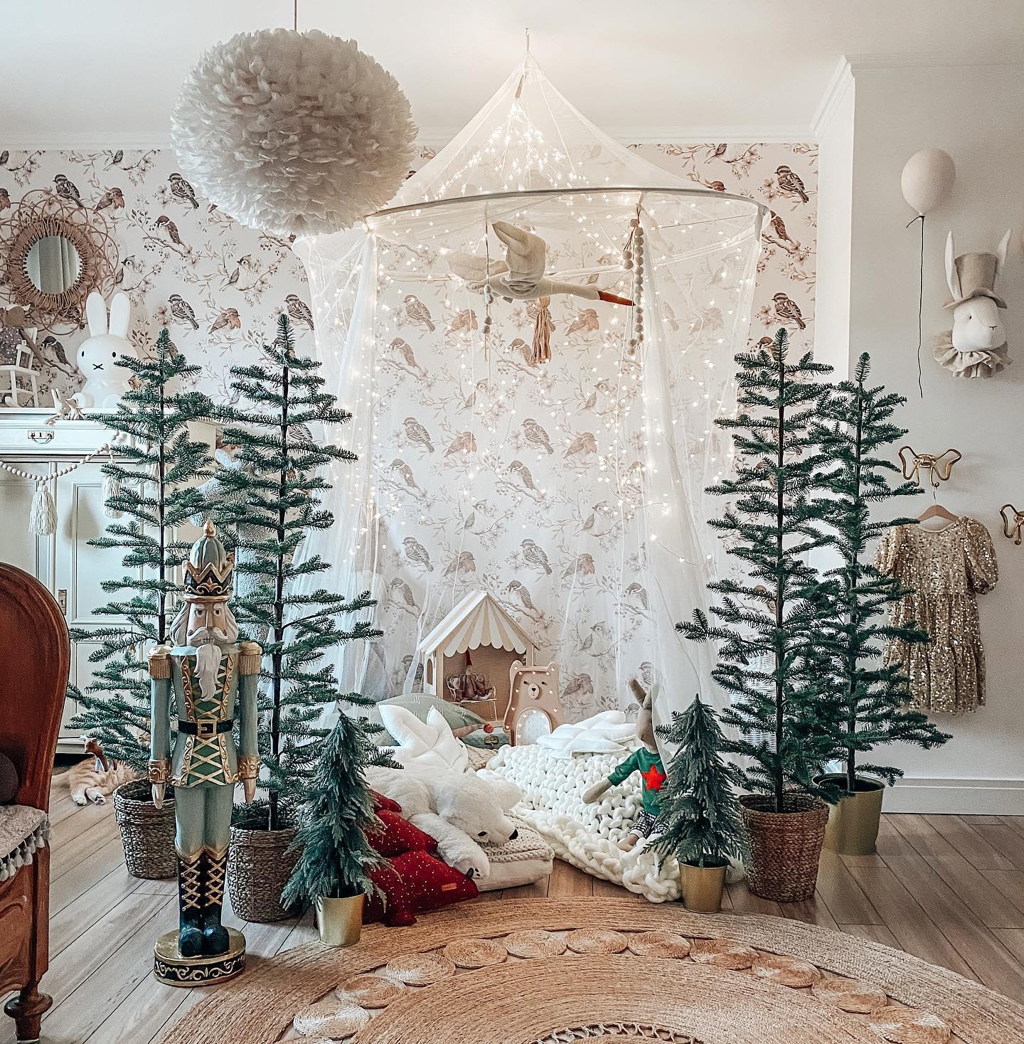 świąteczna kryjówka dla dziecka pod baldachimem otoczona choinkami