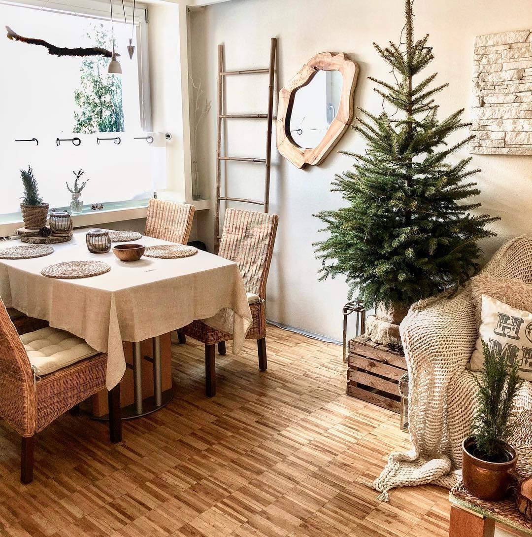 Jadalnia w stylu skandynawskim z niewielką naturalną choinką w doniczce
