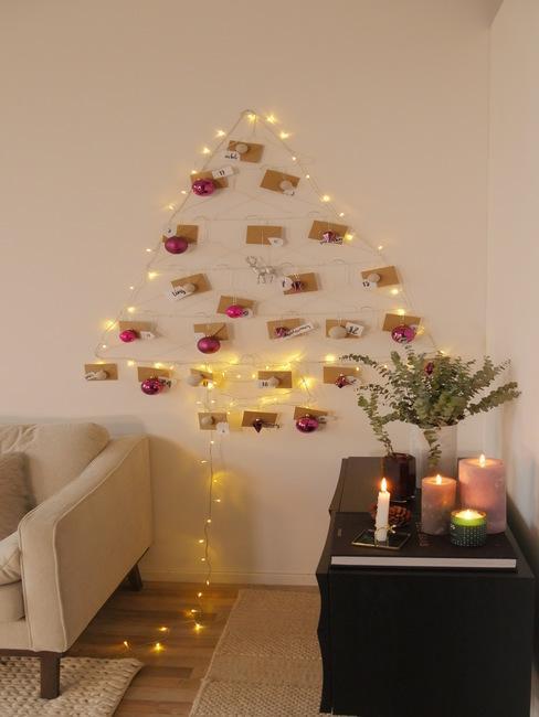 jak zrobić choinkę: światełka na ścianie utworzone na ścianie w kształcie choinki na której ozdobą są koperty na każdy dzień adwentu