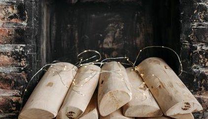 jak obudować kominek: Kominek wykonany z czerwonej cegły we wnętrzu którego poukładane jest drewno do palenia