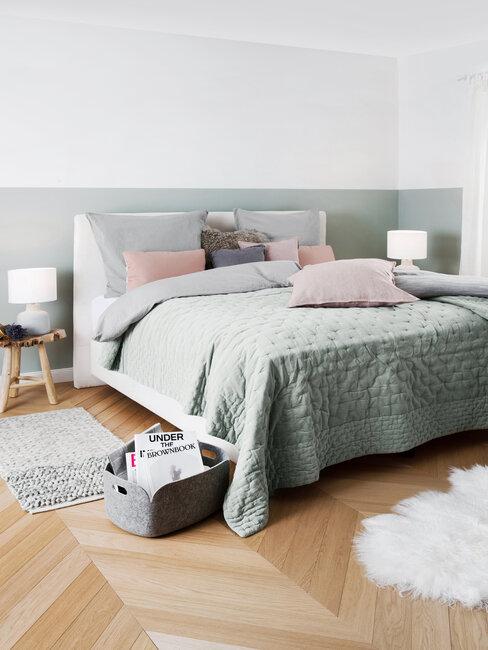 szara sypialnia z drewnianą podłogą, białym dywanikiem, i dodatkami w kolorze rózowym