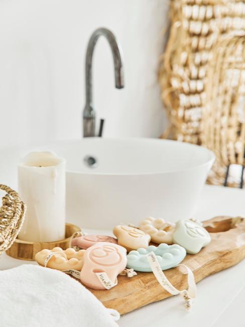 łazienka biała z drewnem: Drewniana taca w łazience na której leżą akcesoria do kąpieli i świeca