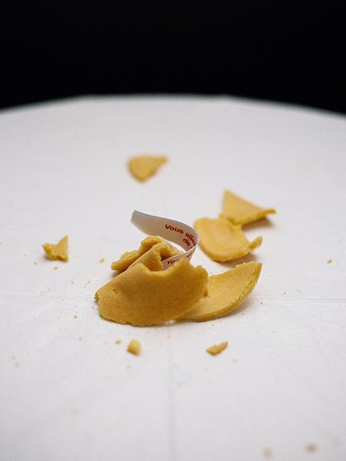 Połamane ciasteczko z wróżbą na białym talerzu