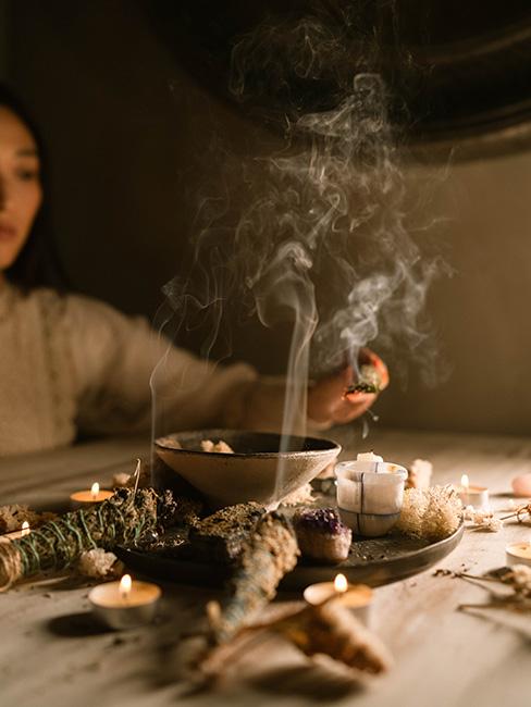 wróżby andrzejkowe: Osoba zapalająca małe kadzidełko