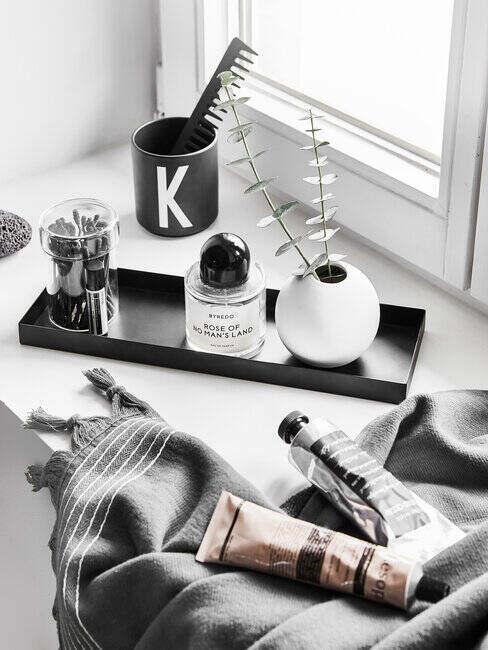 Tacka z kosmetykami i akcesoriami na parapecie łazienki