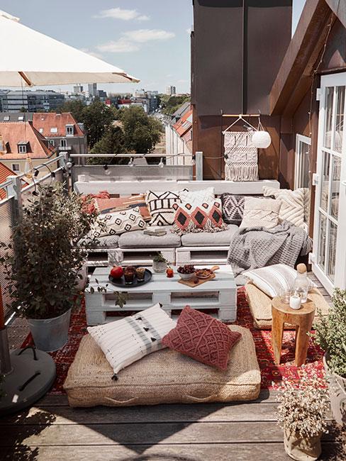 Balkon boho z meblami z palet i dodatkami w naturalnych kolorach