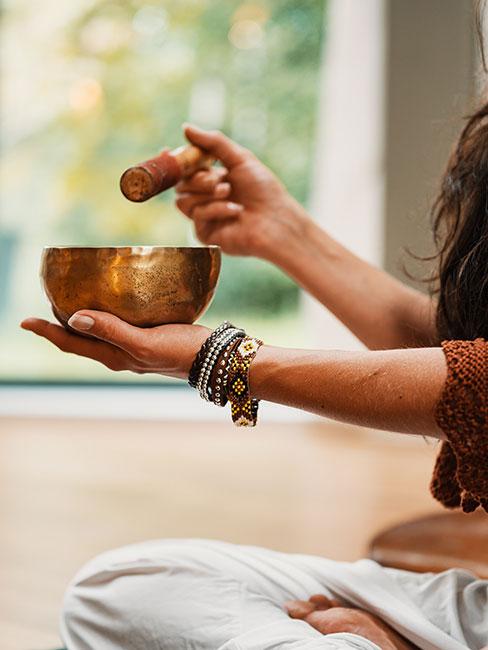 Kobieta uderzająca w misy tybetańskie