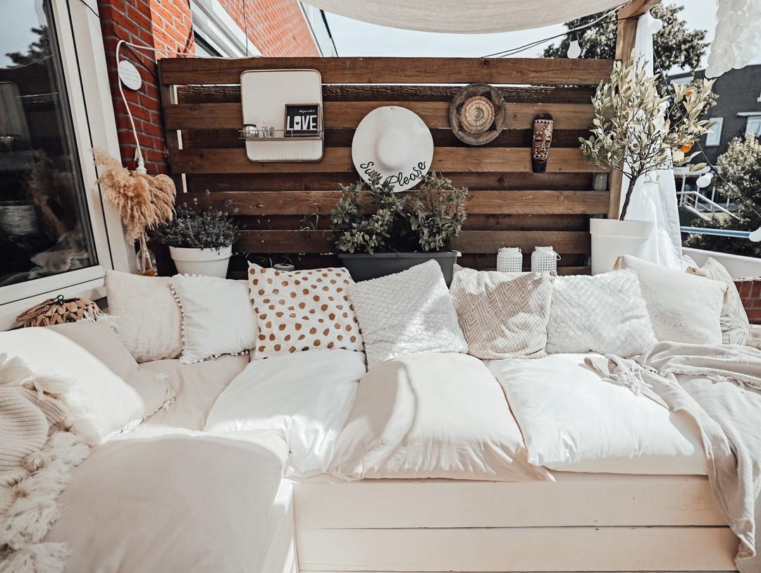 Balkon w bieli w stylu boho z drewnianą ścianą