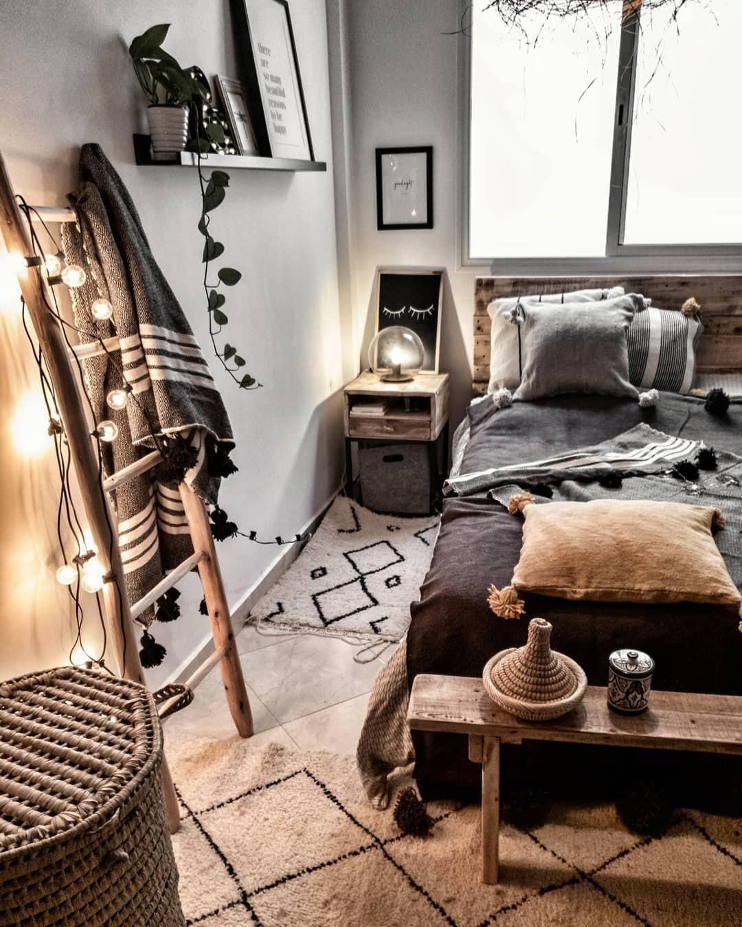 Przytulny salon z ciemnoszarą sofą, dywanem we wzór berberyjski i dekoracjami w stylu boho