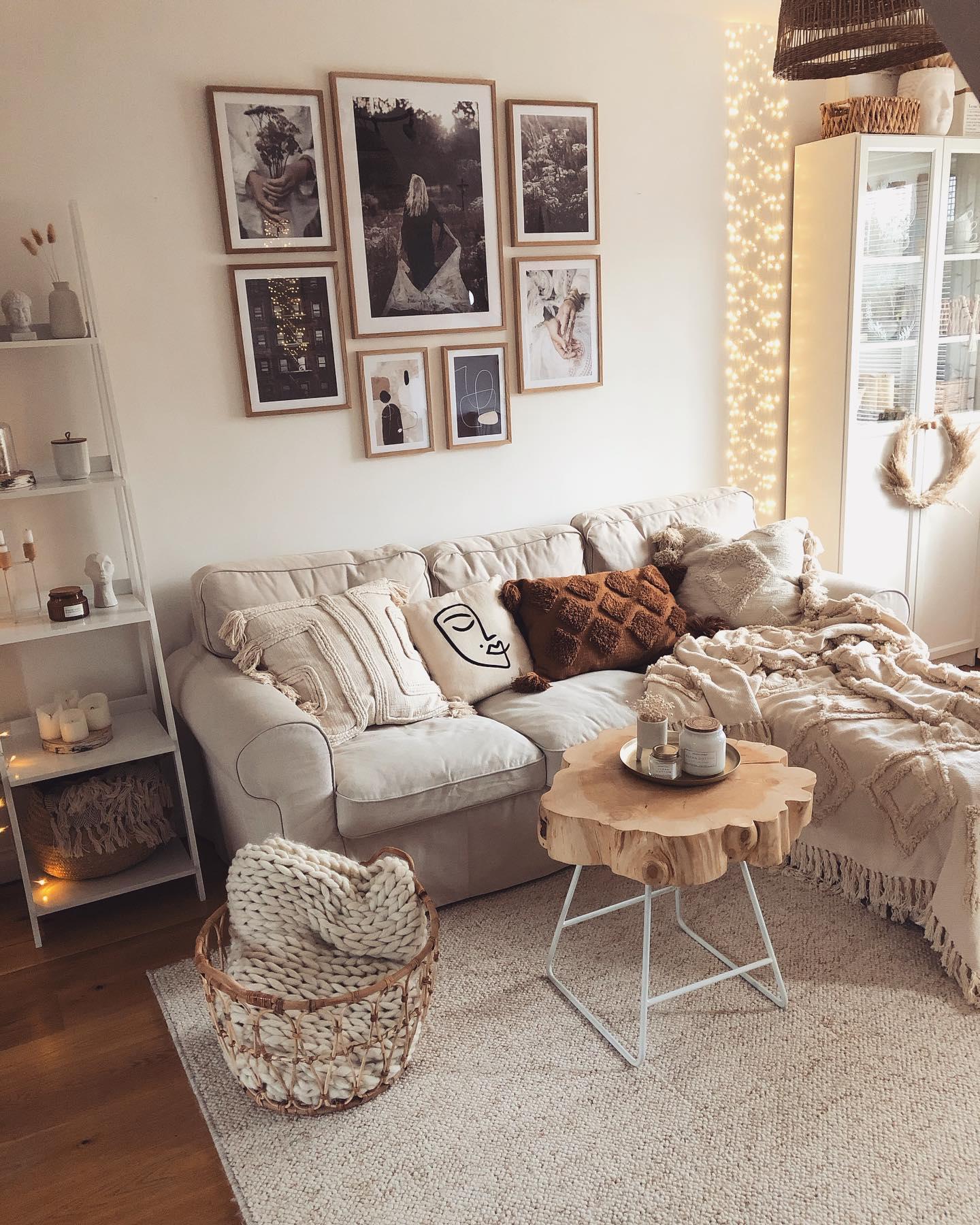 Salon w stylu boho z beżową sofą i brązowymi poduszkami oraz galerią zdjęć na ścianie