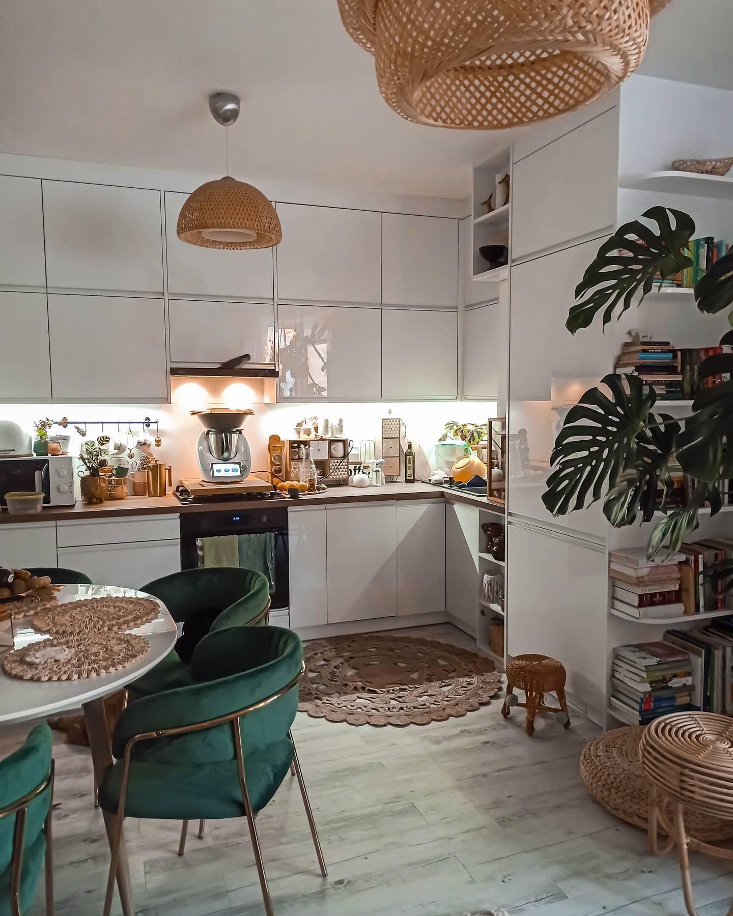 Kuchnia w stylu boho z jadalnią z zielonymi krzesłami i licznymi roślinami