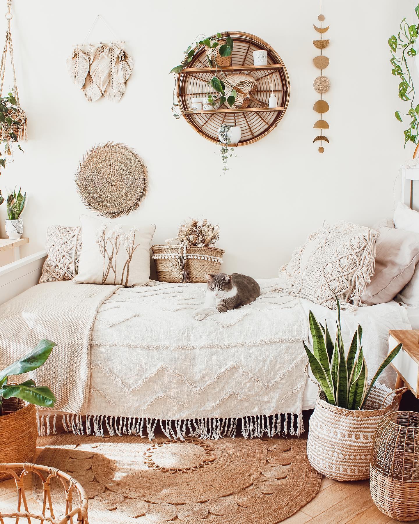 Białobeżowa sypialnia w stylu boho z naturalnymi dekoracjami na ścianie i roślinami