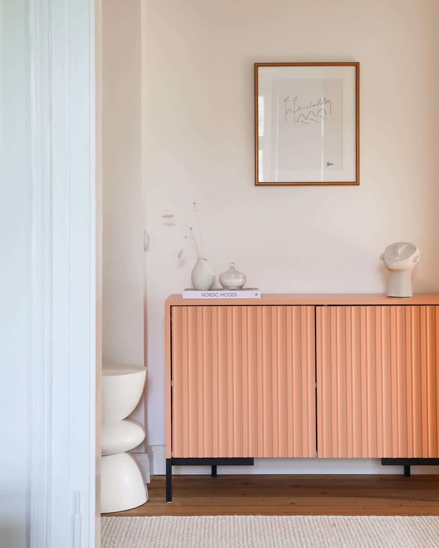 Łososiowa komoda z falistą fakturą na tle jasnej ściany