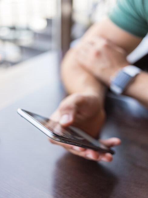 Męska dłoń trzymająca telefon