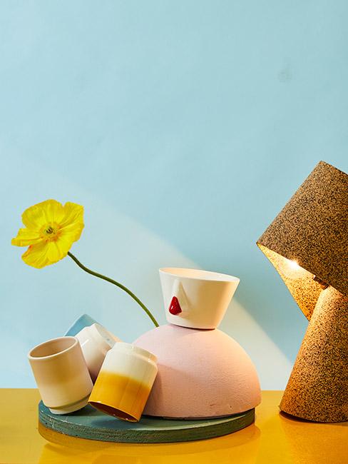 Komplet filiżanek przy lampce na tle błękitnej ściany