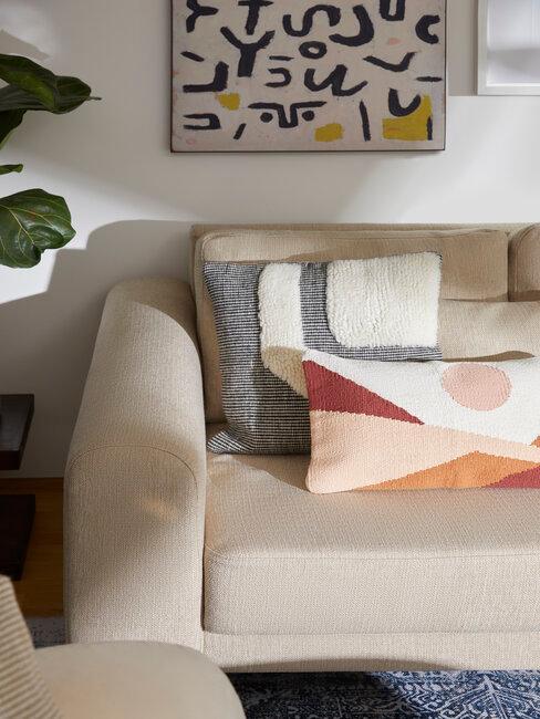 Beżowa sofa z kolorowymi, wzorzystymi poduszkami